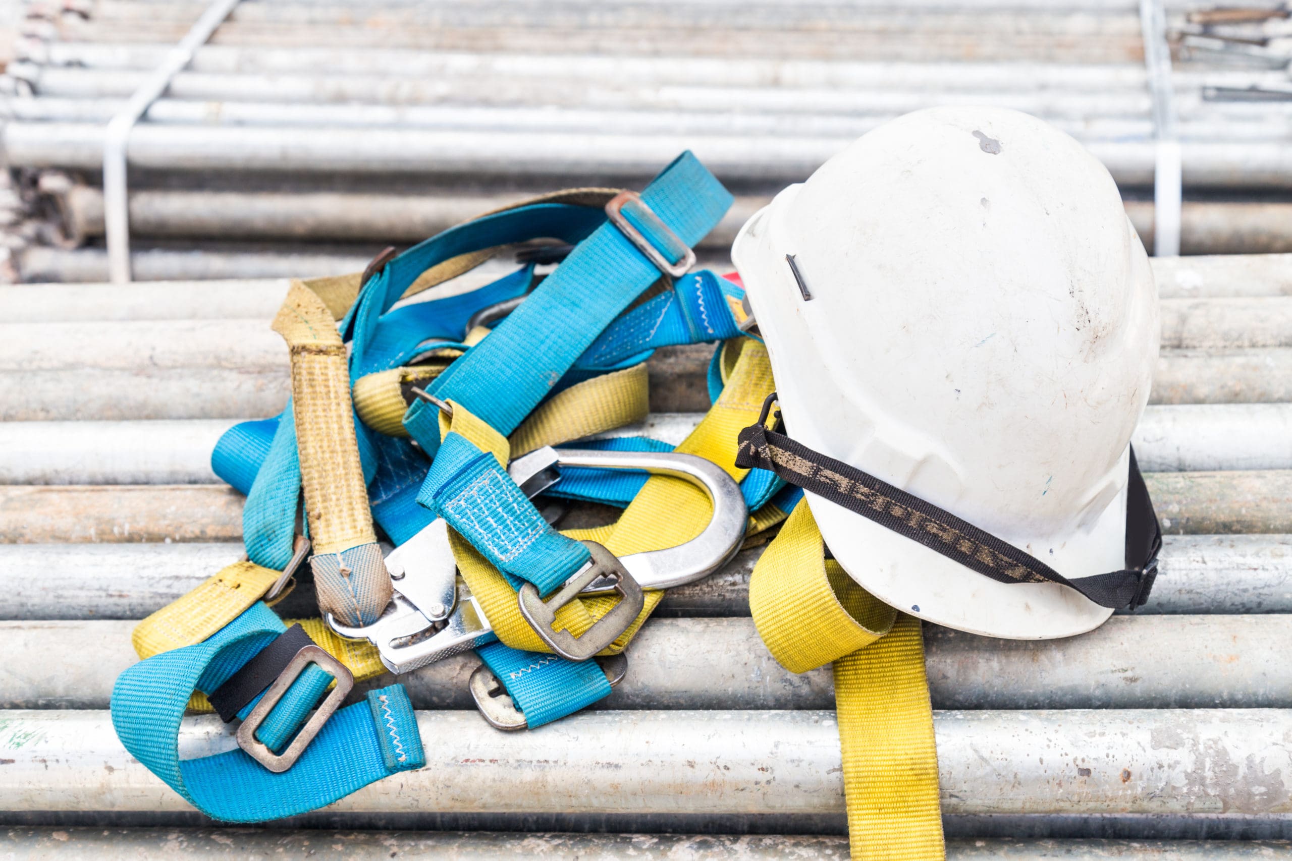 safety harness and construction hard hat at a work site