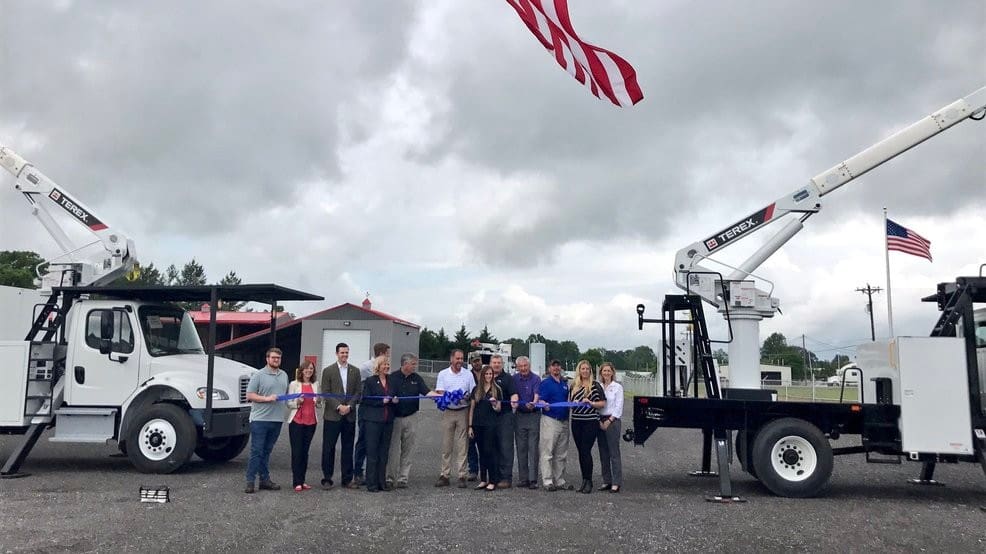 Group of employees at ribbon cutting ceremony for company expansion