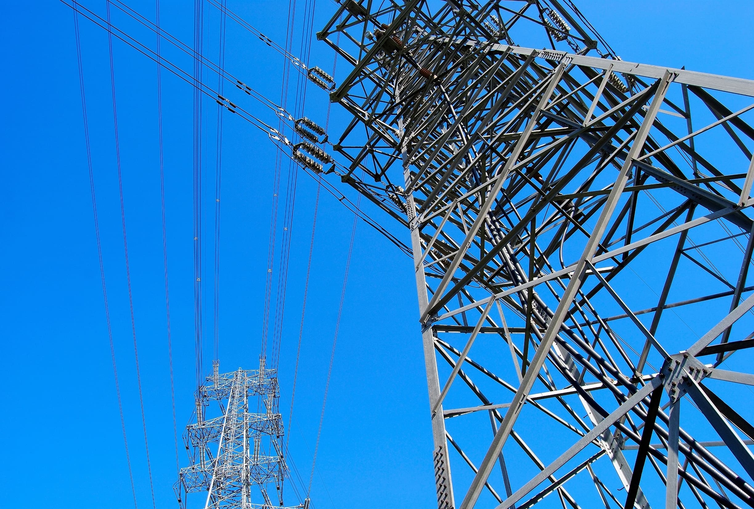 electricity pylons with lines crossing in the sky