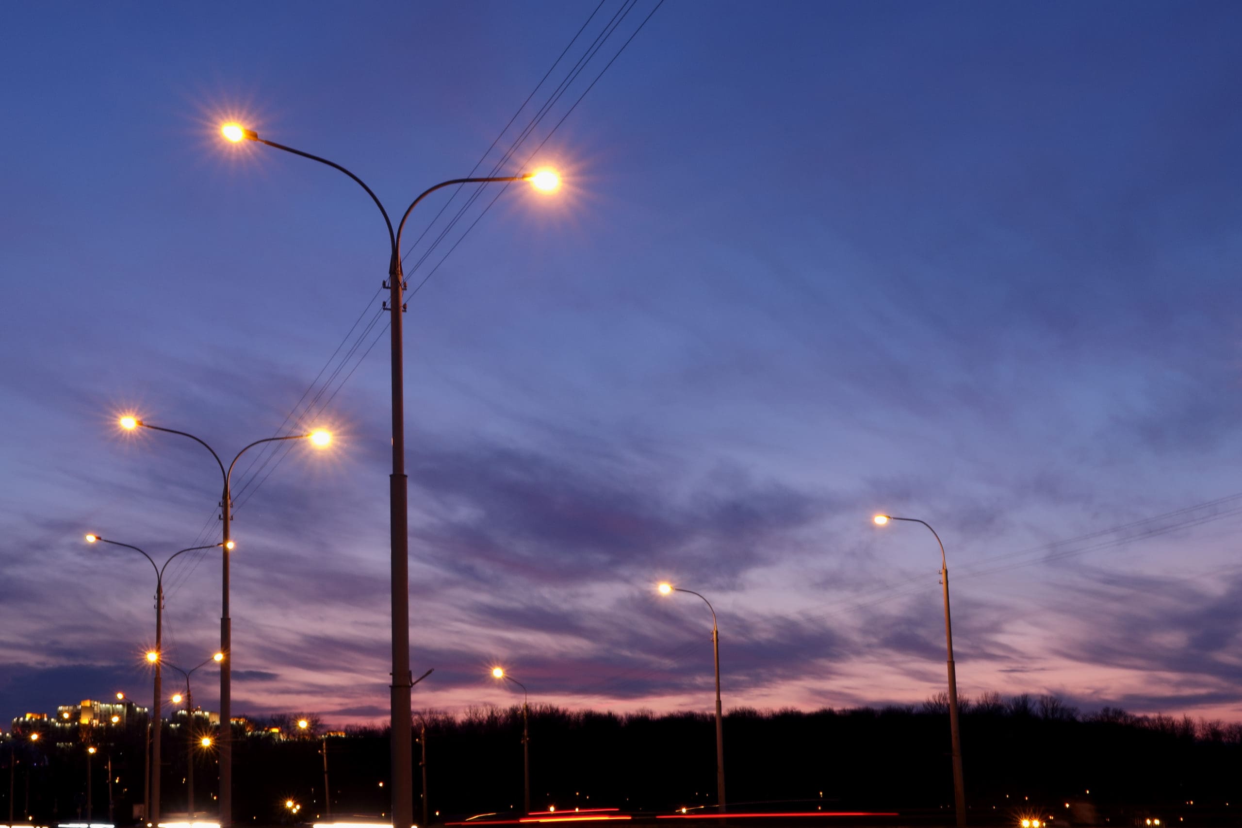 streetlights above a road at dusk