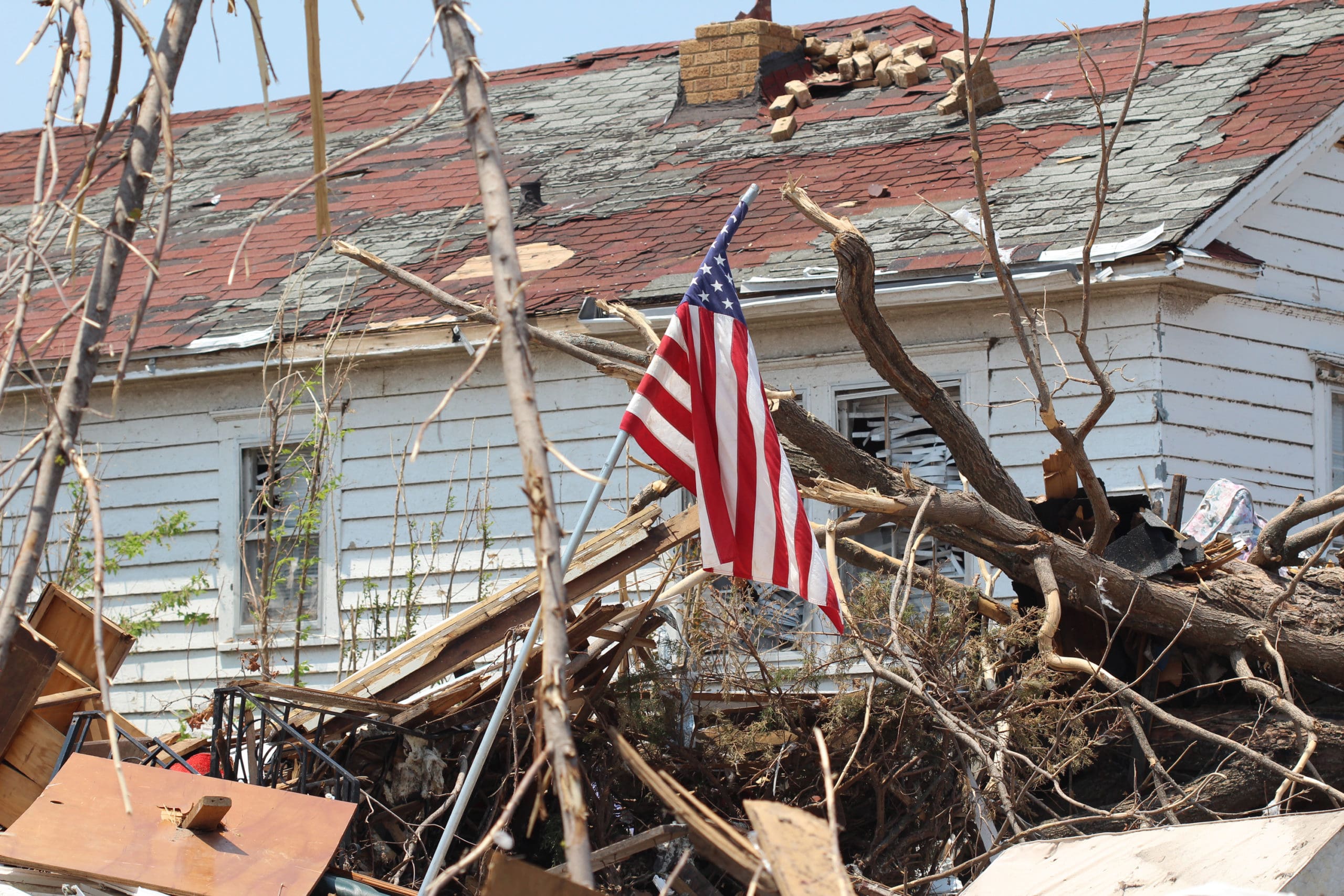 american flag in fallen trees from a storm