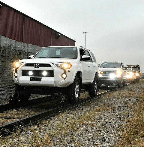 row of hi-rail vehicles parked on rail tracks