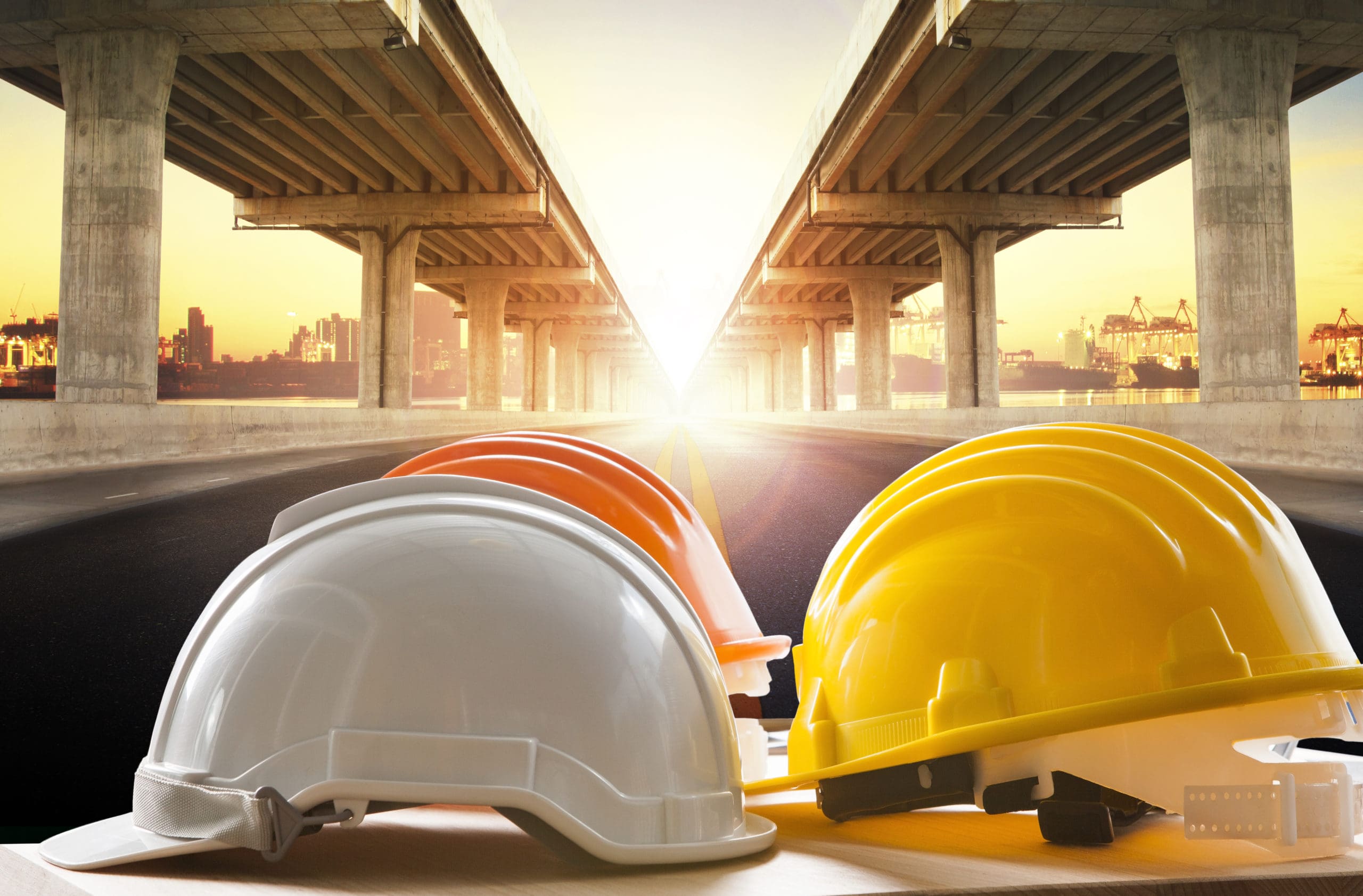 safety helmet on civil engineering working table against infrastructure bill bridge construction in urban scene