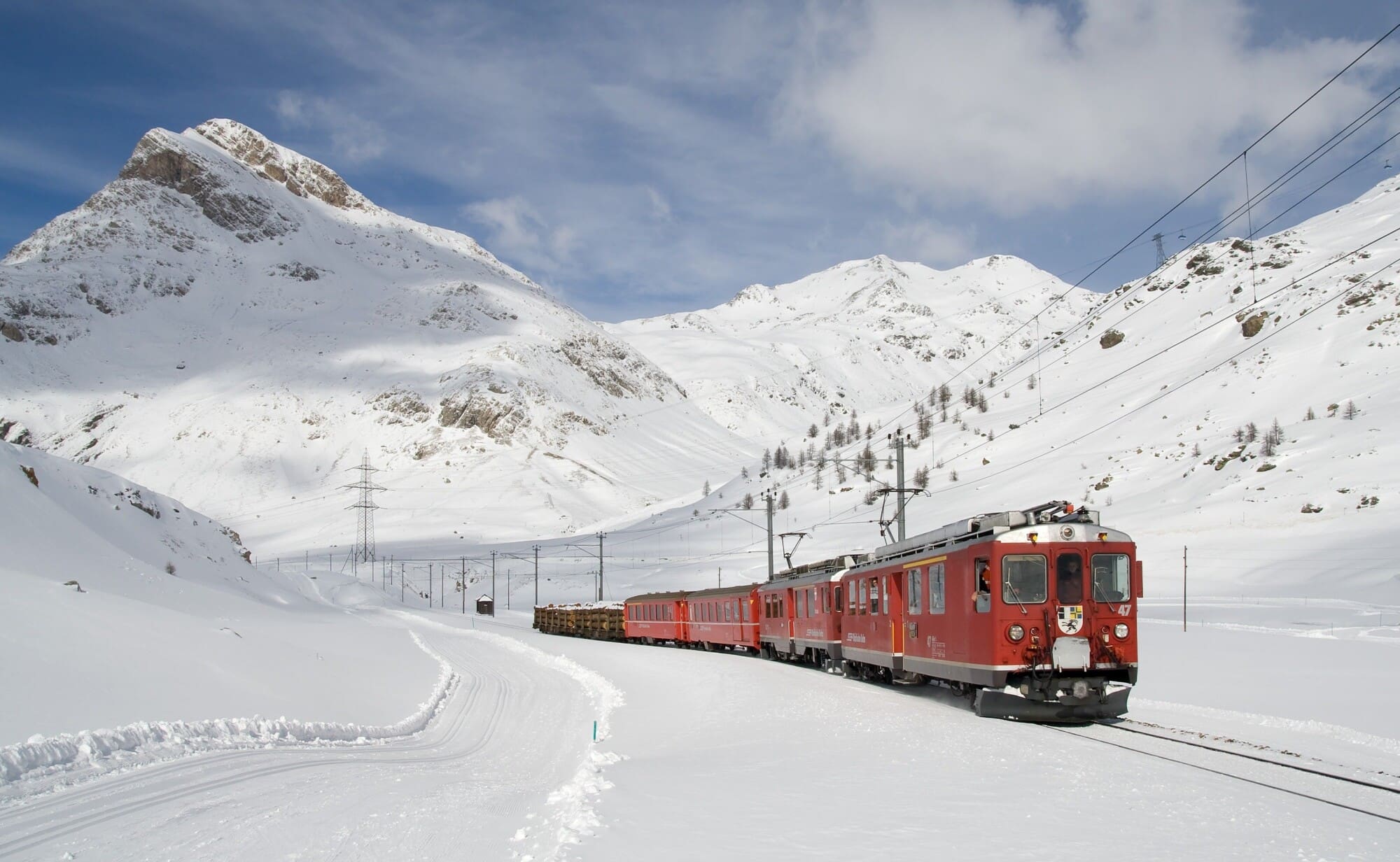 a train moving on railroad tracks through snowy winter mountains